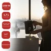 A woman is holding a black electric kettle with a digital display in a modern kitchen setting, with sunlight streaming in from a window. Produktbild-Vorschau