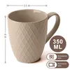 A beige ceramic mug with a textured diamond pattern is shown against a white background. Dimensions and capacity are indicated with text and icons. Produktbild-Vorschau