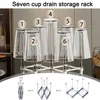 A product image displaying a cup drain storage rack holding multiple glasses, with smaller inset images showing its collapsible mechanism. Produktbild-Vorschau