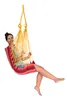 A woman is sitting in a colorful hammock chair. Produktbild-Vorschau
