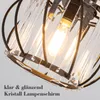 Close-up of a crystal lampshade with a black metal frame. Voir les images du produit