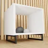 A white cube-shaped shelf with black metal legs, decorated with two decorative spheres, set against a slatted wooden background. Voir les images du produit