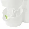 A close-up view of a white plastic herb pot with a small green flower detail. Náhled obrázku produktu