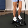 A person is using a stepper machine on a black mat in a room with a blue cabinet in the background. Voir les images du produit
