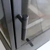 A close-up view of a black metal handle on a glass door, likely part of a fireplace or stove. Produktbild-Vorschau