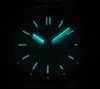 Close-up of a watch face in low light, with luminous hands and markers. Náhled obrázku produktu
