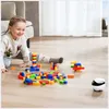 A young girl plays with building blocks on the floor next to a small robot. Produktbild-Vorschau