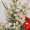 Hands decorating a Christmas tree with artificial poinsettia ornaments. Produktbild-Vorschau