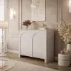 A modern living room with a white cabinet, floor lamp, and decorative items. Produktbild-Vorschau
