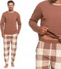 A man is shown wearing a brown long-sleeved pajama top and plaid pajama pants. Produktbild-Vorschau