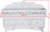A white wooden wall-mounted organizer with three drawers and two hooks, featuring decorative cutouts and a shell motif at the top. Dimensions are indicated with red lines and text. Náhled obrázku produktu