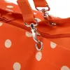 A close-up view of the strap and clasp of an orange polka dot bag. Podgląd zdjęcia produktu