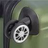 A close-up view of the wheels and side of a green suitcase. Anteprima dell’immagine prodotto