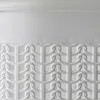 A close-up view of the textured upper part and the patterned lower part of a white laundry basket. Voir les images du produit
