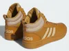 A pair of brown Adidas mid-top sneakers with beige accents and white stripes. Anteprima dell’immagine prodotto