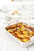 A table setting with a roasting pan filled with baked pears, cups of tea, and crackers. Produktbild-Vorschau