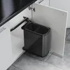 A pull-out trash can with two compartments inside a kitchen cabinet. Voir les images du produit