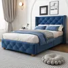 A bedroom setting with a blue upholstered bed. Produktbild-Vorschau