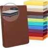 A stack of colorful fitted sheets and a large brown fitted sheet in the foreground with a circular inset showing a bed. Produktbild-Vorschau