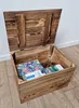 An open wooden chest with a lid, containing some items inside. Náhled obrázku produktu