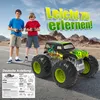 Two boys are standing on a road with a monster truck in front of them, with mountains in the background. Produktbild-Vorschau