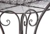 Close-up view of the decorative metal base of a table, showing intricate scrollwork and a patterned tabletop. Produktbild-Vorschau