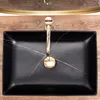 A top-down view of a black marble sink with a gold faucet. Produktbild-Vorschau
