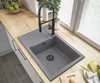 A modern kitchen sink with a black faucet and a wooden countertop. Podgląd zdjęcia produktu