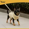 A small black and tan dog wearing a beige knitted sweater and a leash walks on a paved path. Náhľad obrázku produktu