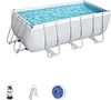 A rectangular above-ground swimming pool filled with blue water, supported by a silver metal frame. Below the pool are three accessories: a water filter pump, a ladder, and a blue circular object. Produktbild-Vorschau
