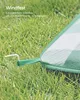 A close-up of a picnic blanket secured to the grass with a stake. Produktbild-Vorschau