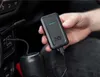 A person is holding a black Quad Lock wireless CarPlay adapter in a car. Náhľad obrázku produktu