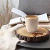 A cozy scene with a mug of coffee, a book, and cinnamon sticks on a wooden slice. Produktbild-Vorschau