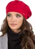 A woman wearing a red beret and a black turtleneck.