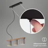 A close-up view of a person adjusting the height of a pendant lamp, with the lamp itself visible in the background. Produktbild-Vorschau