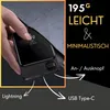 A hand holding a black power bank with a digital display showing 100%. The background is dark with stars, and there are text overlays and arrows indicating features. Produktbild-Vorschau