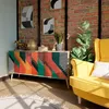A colorful sideboard in a living room setting with a yellow armchair and plants. Anteprima dell’immagine prodotto