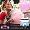 A woman smiling and holding cotton candy next to a retro-style cotton candy machine. Produktbild-Vorschau
