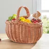 A wicker basket filled with fresh produce and a baguette, placed on a wooden table. Produktbild-Vorschau
