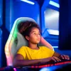 A young girl is sitting in a gaming chair and playing a video game. Produktbild-Vorschau