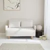 A cream-colored sofa with two pillows sits in a minimalist room with a framed artwork on the wall and a rug on the floor. Anteprima dell’immagine prodotto