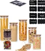 A collection of glass storage jars filled with various food items, along with a sheet of chalkboard stickers and individual chalkboard labels. Produktbild-Vorschau