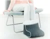 A person sitting on a chair with their feet in a heated foot warmer. Produktbild-Vorschau