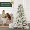 A woman and her dog are sitting on a couch next to a decorated artificial Christmas tree. Podgląd zdjęcia produktu