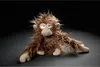 A plush toy monkey is lying on a dark surface against a black background. Náhled obrázku produktu