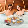A couple relaxing in a hot tub with a floating tray of snacks and drinks. Náhled obrázku produktu