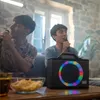 Two men are singing karaoke with a portable speaker. Produktbild-Vorschau