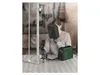 A person is welding a metal gate in a workshop setting. Produktbild-Vorschau