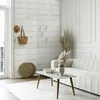 A modern living room with a white sofa, coffee table, and decorative items. Anteprima dell’immagine prodotto