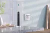 An electric toothbrush is charging on a bathroom counter. Produktbild-Vorschau